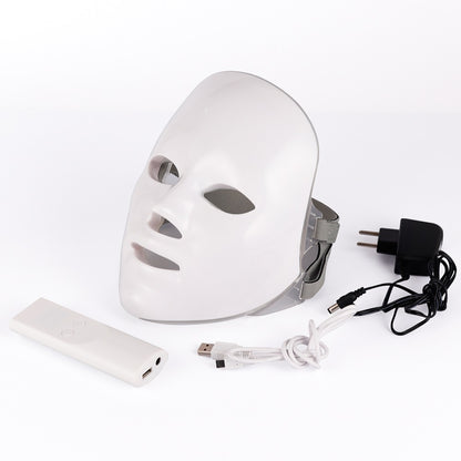 White LED face mask with power adaptor, USB cable, and remote control on a white background